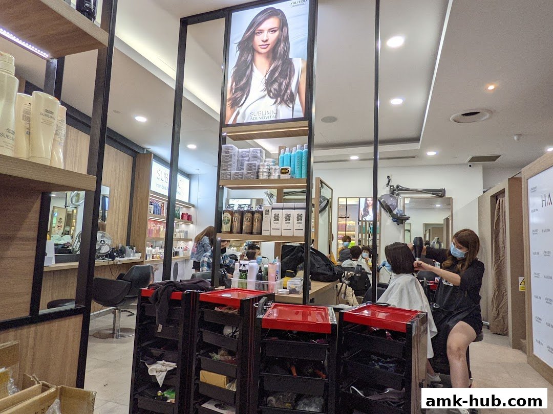 Hairdresser styling a client's hair with a hairdryer in a modern salon.