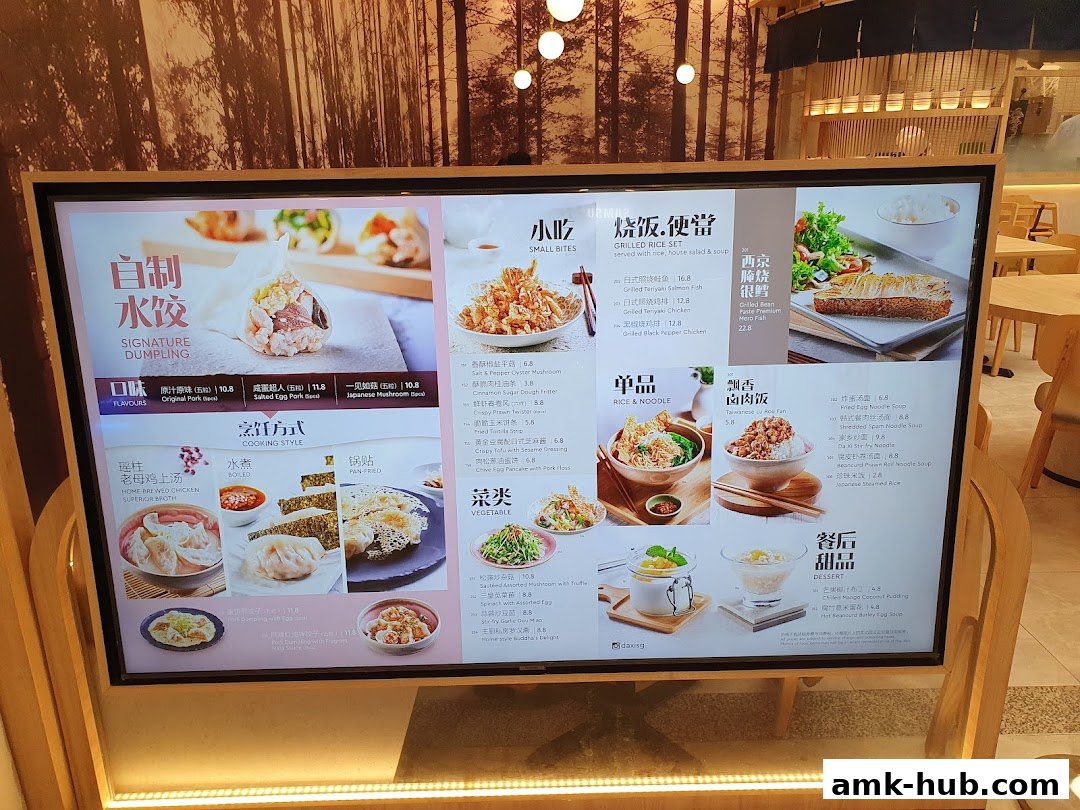 A digital menu board displaying various dumplings, rice dishes, and desserts with prices.