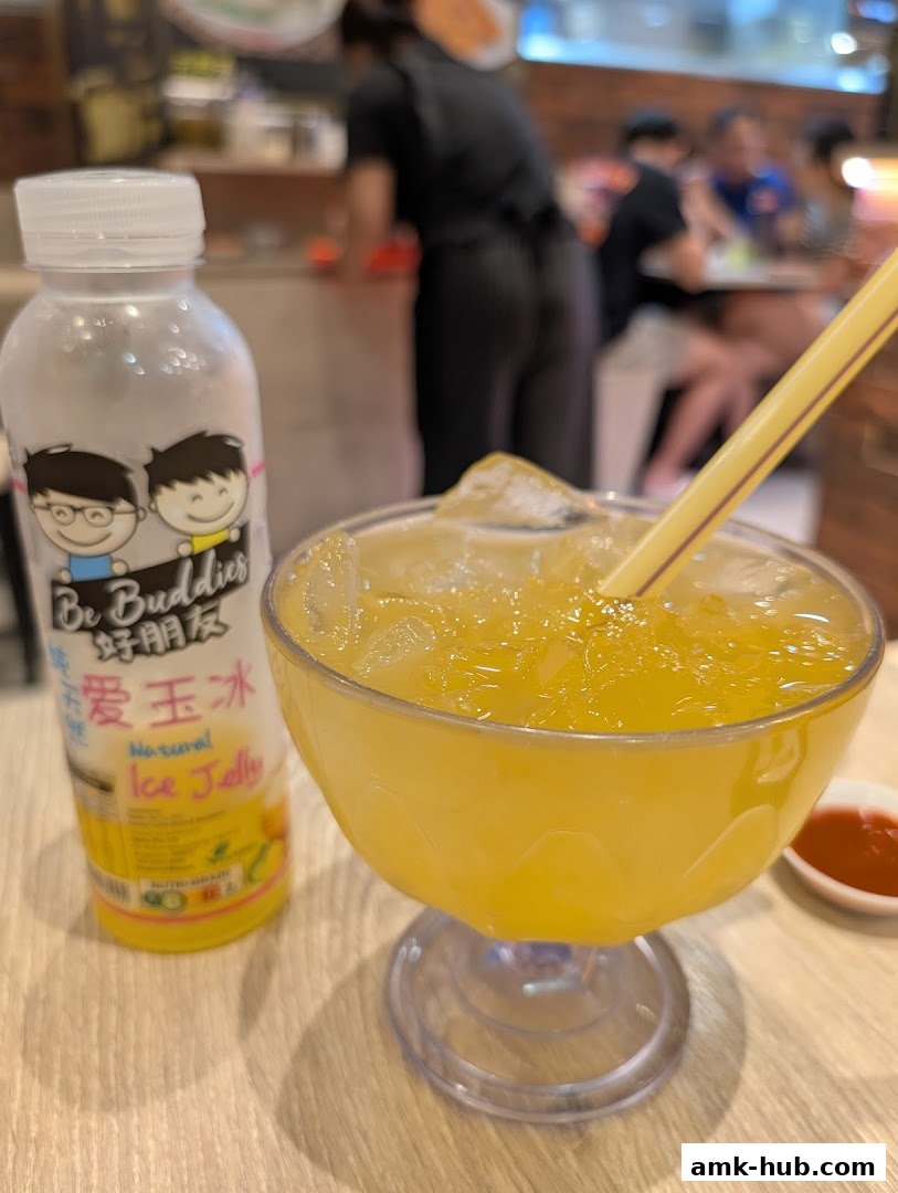 A refreshing glass of orange ice jelly drink with a bottle of "Be Buddies" ice jelly drink.