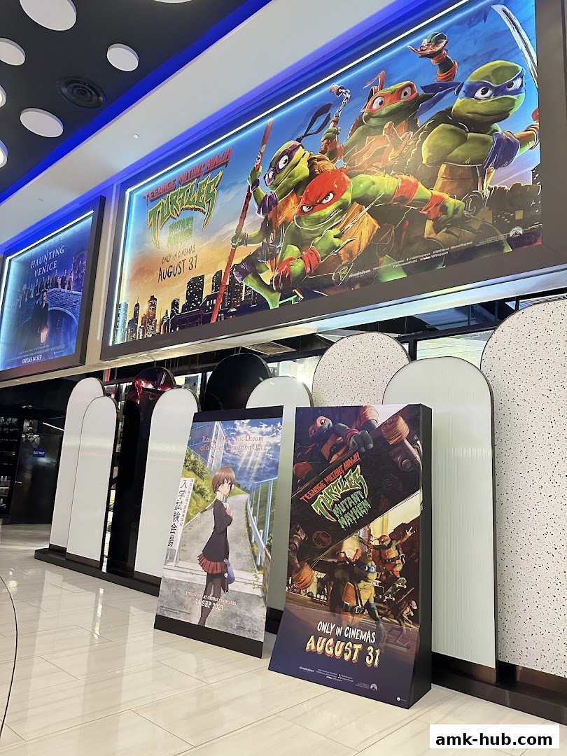 Movie posters for 'Haunting Venice' and 'Teenage Mutant Ninja Turtles: Mutant Mayhem' displayed at a cinema.