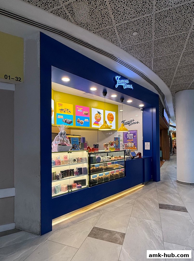 A Famous Amos cookie shop with a bright blue facade and display cases filled with cookies.