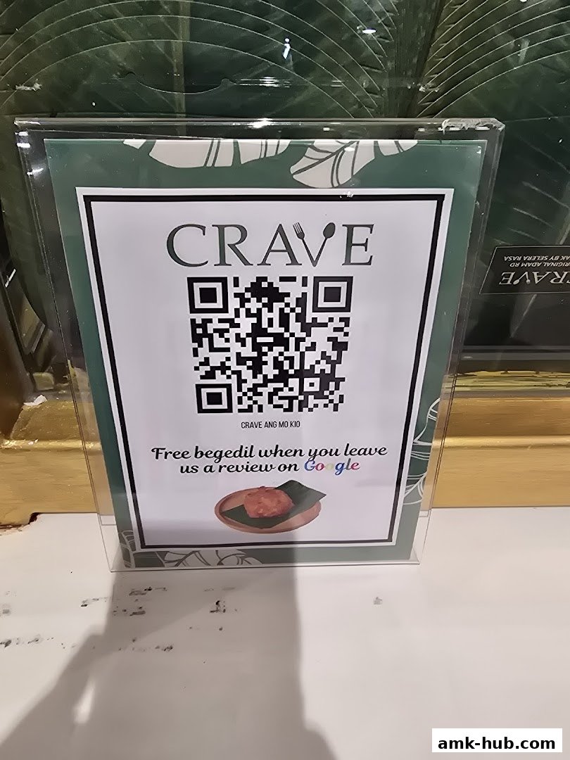 A sign offering free begedil for leaving a Google review at Crave Nasi Lemak.