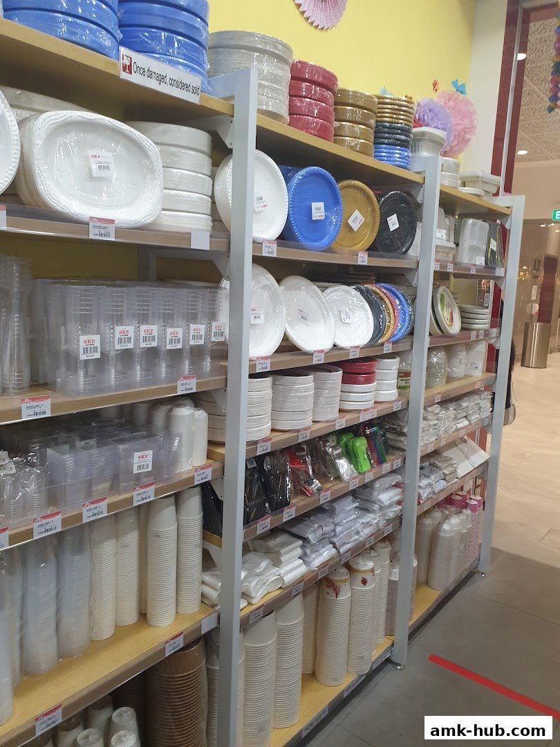Shelves stocked with various disposable plates, cups, and party supplies in different colors.
