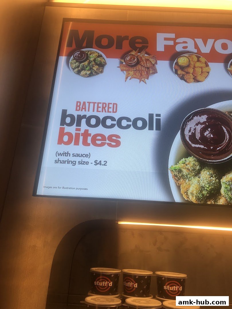 A menu board advertising battered broccoli bites with sauce.