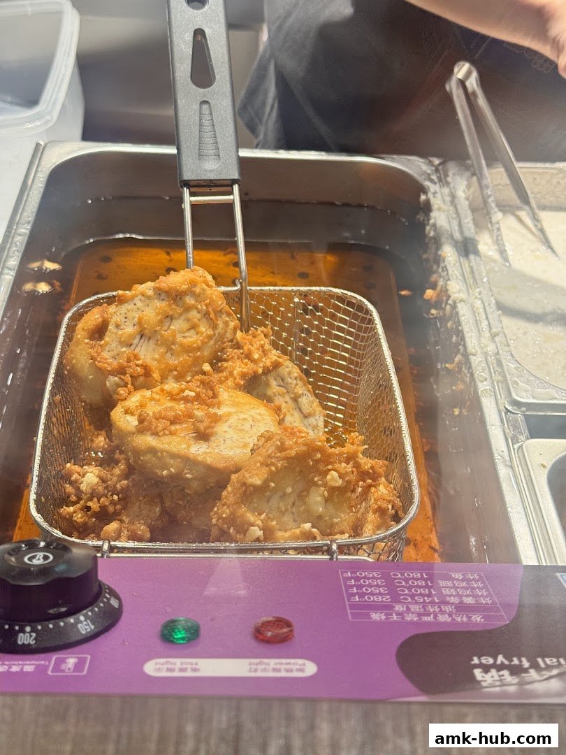 A basket of golden-brown fried food is being lifted from a deep fryer.