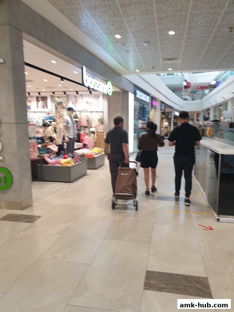 The Bossini store entrance with mannequins displaying clothing and shoppers walking by.