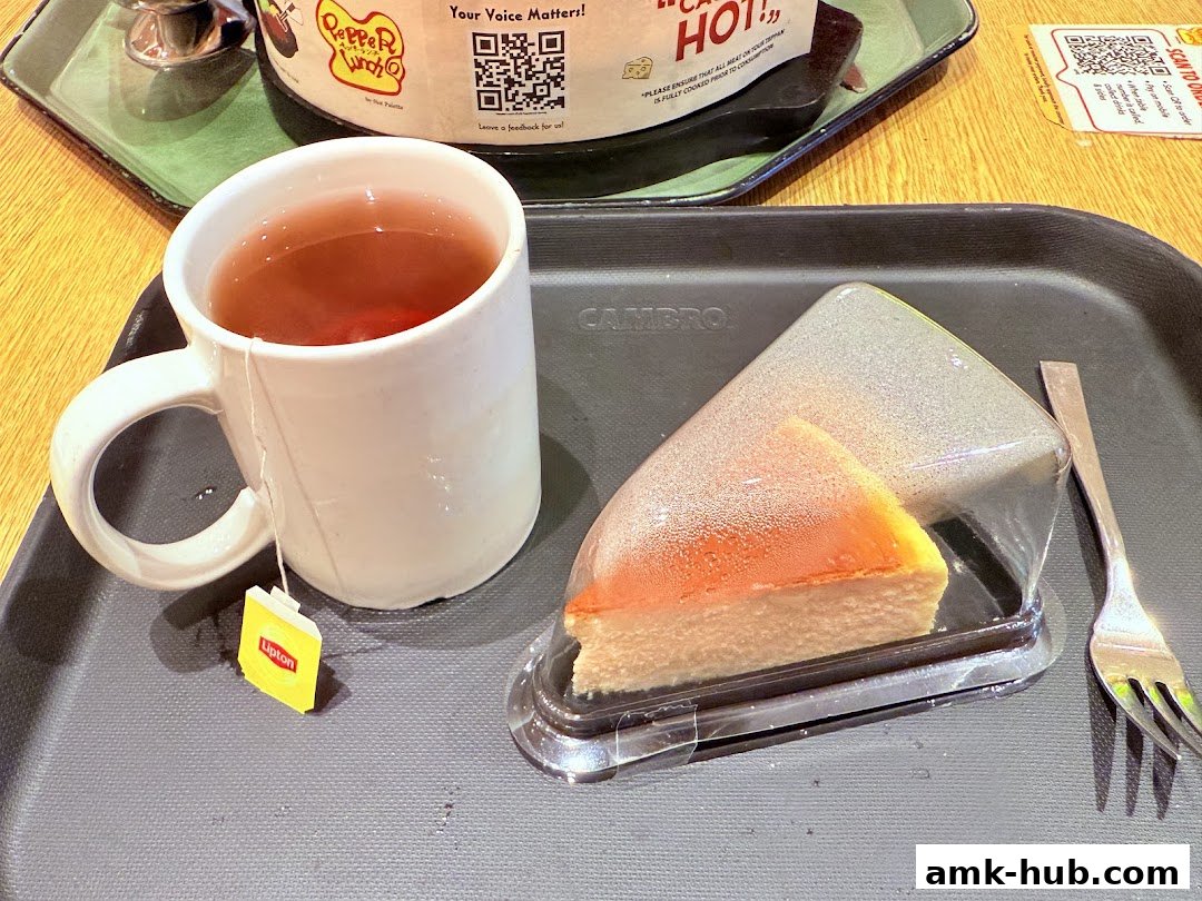 A slice of cheesecake and a cup of tea on a tray at Pepper Lunch.