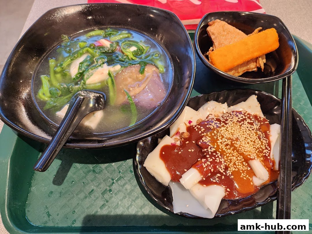 A close-up of three bowls of food, including soup, noodles, and fried items.