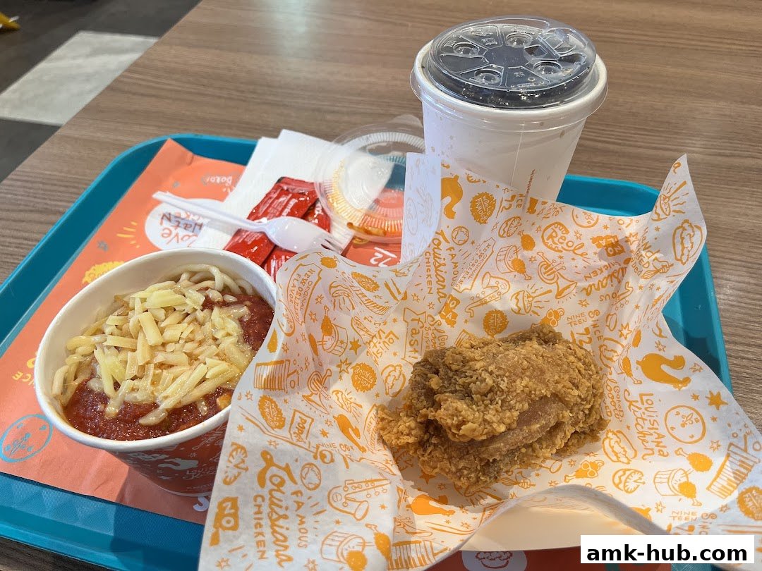 A tray with Popeyes fried chicken, spaghetti, a drink, and condiments.