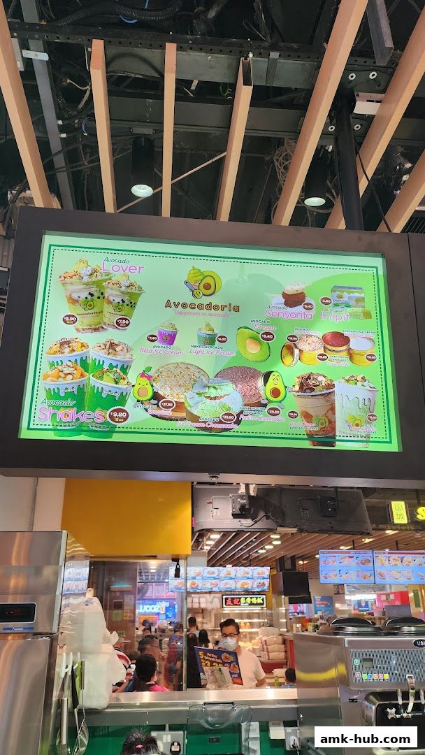 A brightly lit menu board showcasing various avocado-themed desserts and drinks.