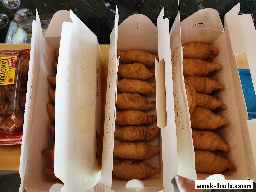 Several boxes filled with golden-brown pastries, with a package of takoyaki in the background.
