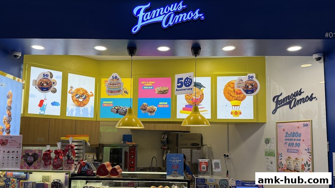 Famous Amos shop front with colorful displays of cookies, brownies, and muffins.