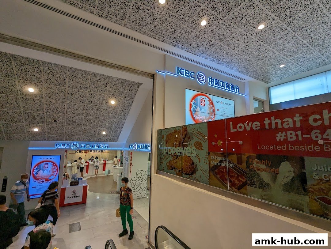 The ICBC Ang Mo Kio Sub-Branch bank entrance with customers and promotional displays.