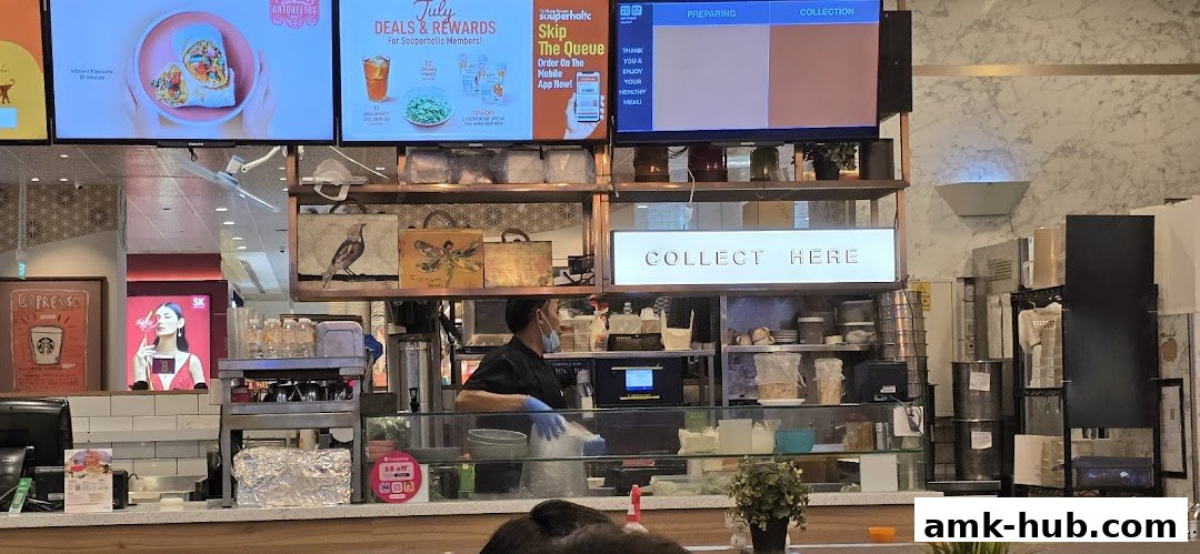 A busy counter at The Soup Spoon with staff preparing orders and a 'Collect Here' sign.