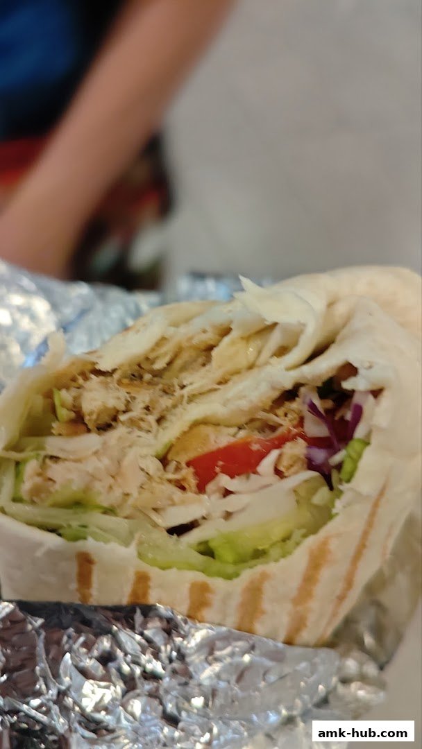 A close-up shot of a delicious chicken wrap filled with fresh vegetables.