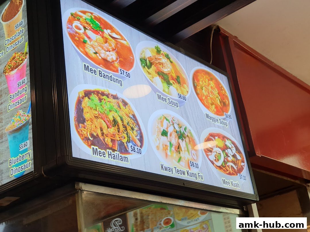 A digital menu board displaying various noodle dishes and drinks with prices.
