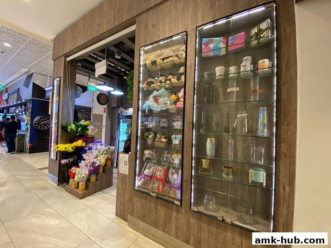 A flower shop display with bouquets, stuffed animals, and decorative items in glass cabinets.
