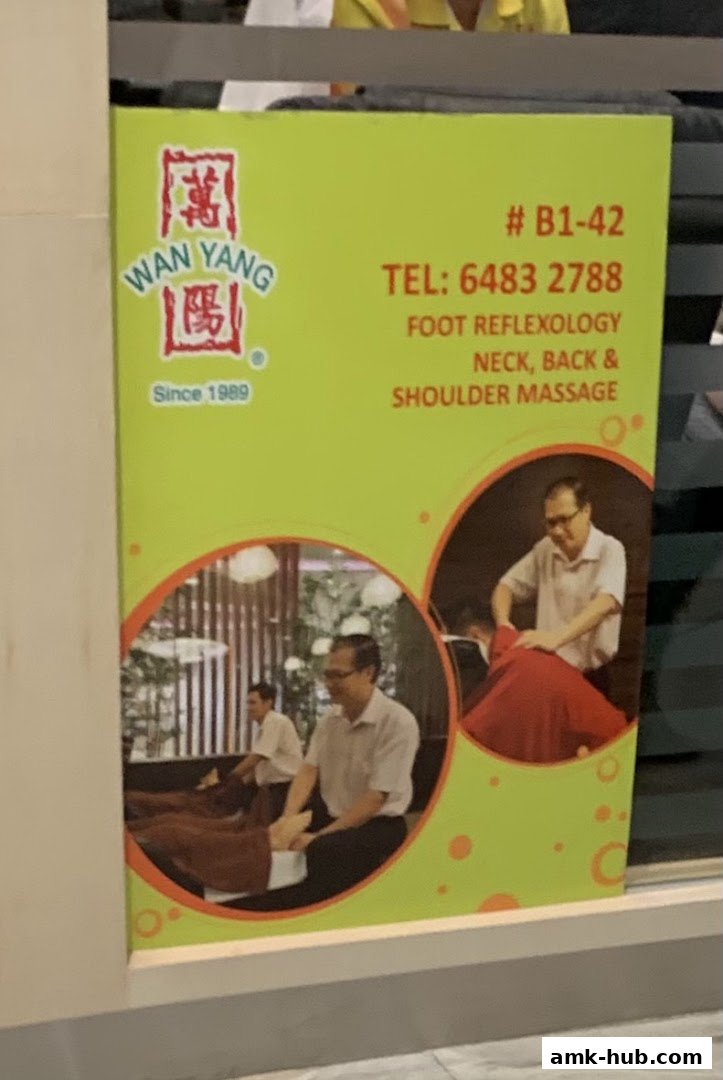 A sign for Wan Yang Health Product and Foot Reflexology Centre, advertising services and contact information.