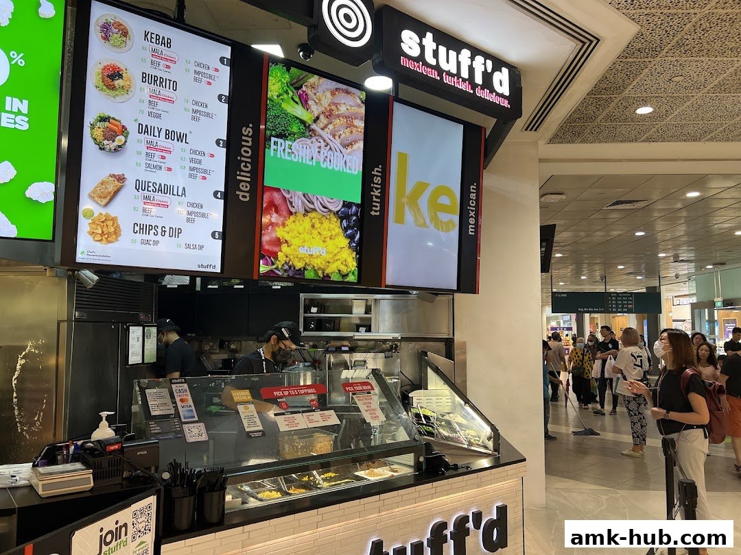 A Stuff'd shop with a menu board displaying food items and a counter with staff.