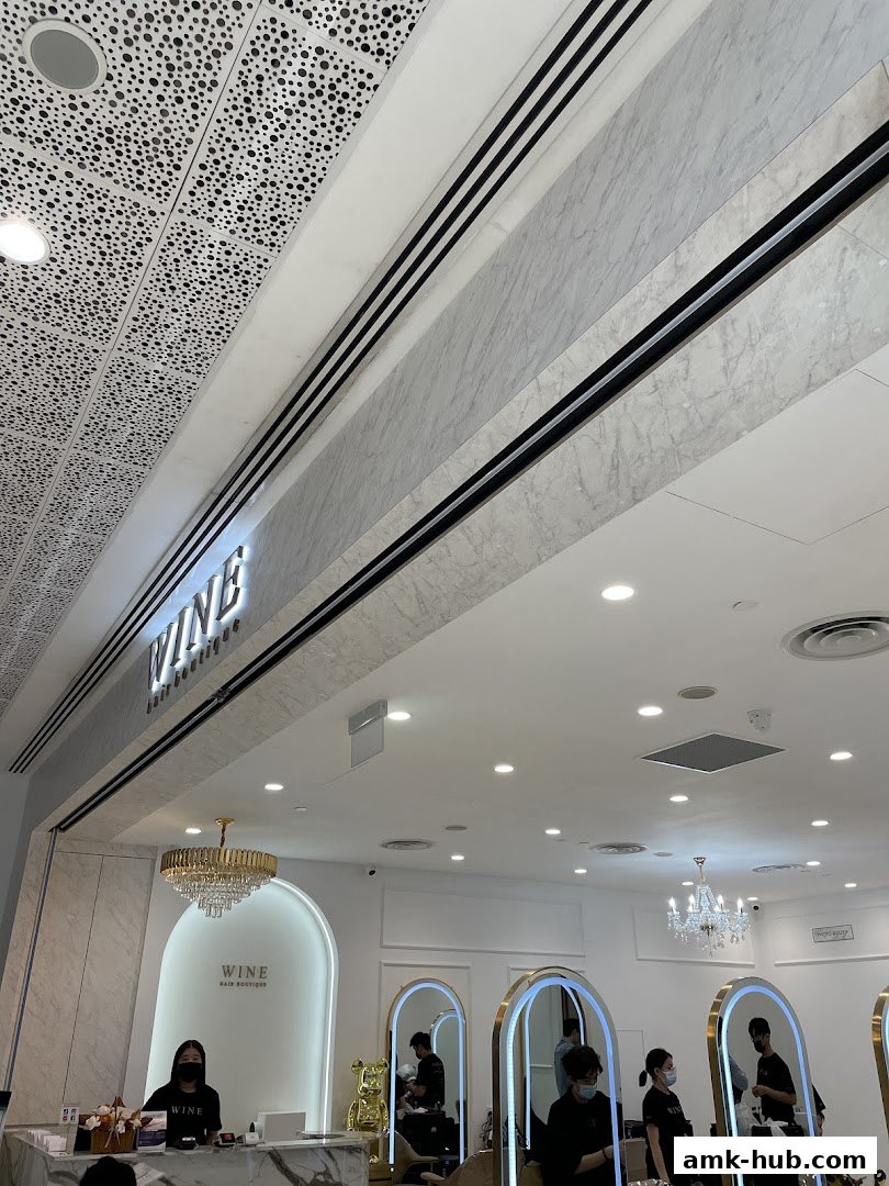 Interior of a modern hair salon with stylists at work and a reception desk.