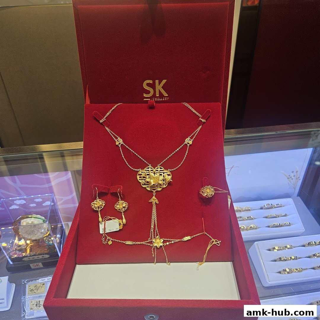 A red velvet box displays a gold jewelry set, including a necklace, earrings, bracelet, and ring.