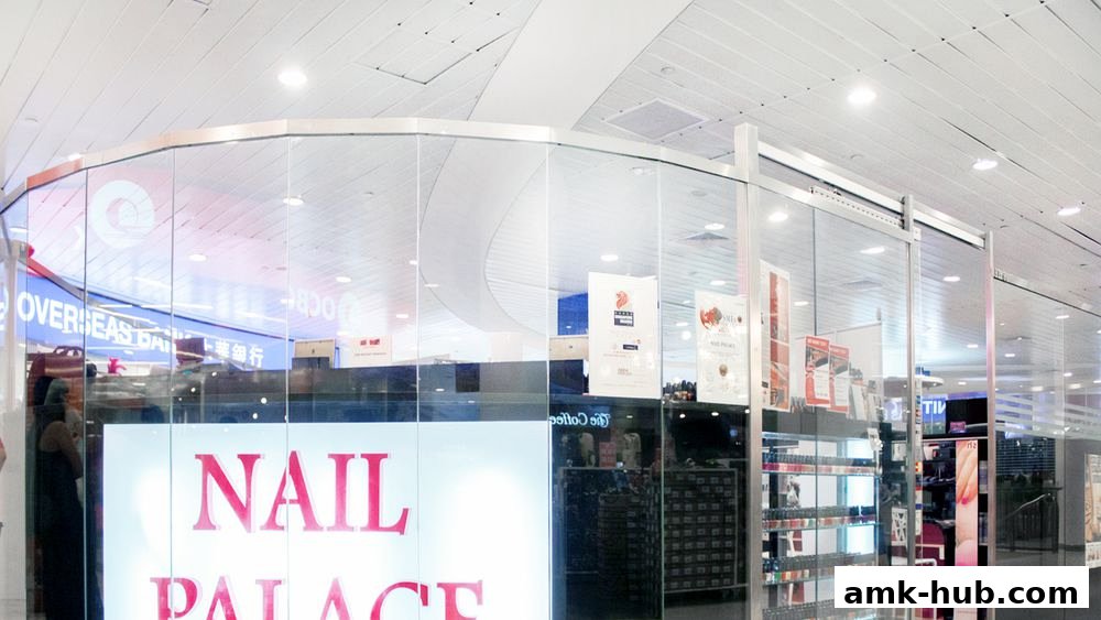 The exterior of a modern nail salon with large glass windows displaying products and the shop name.