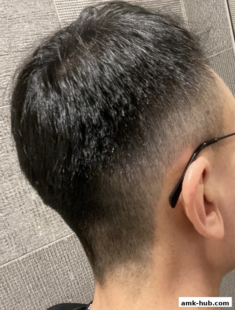 Close-up of a person's neatly cut hair and ear, showcasing a fresh fade.
