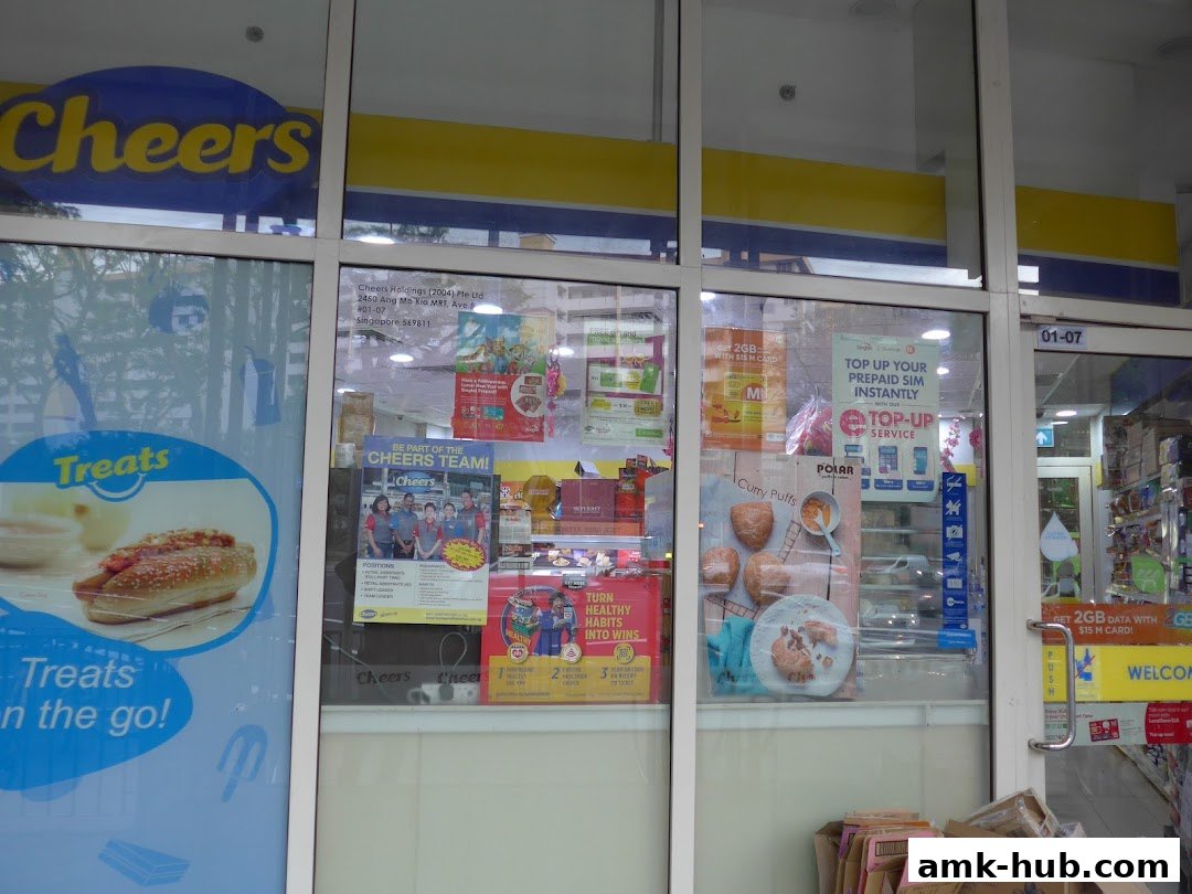 The exterior of a Cheers convenience store with promotional posters and signage visible through the windows.