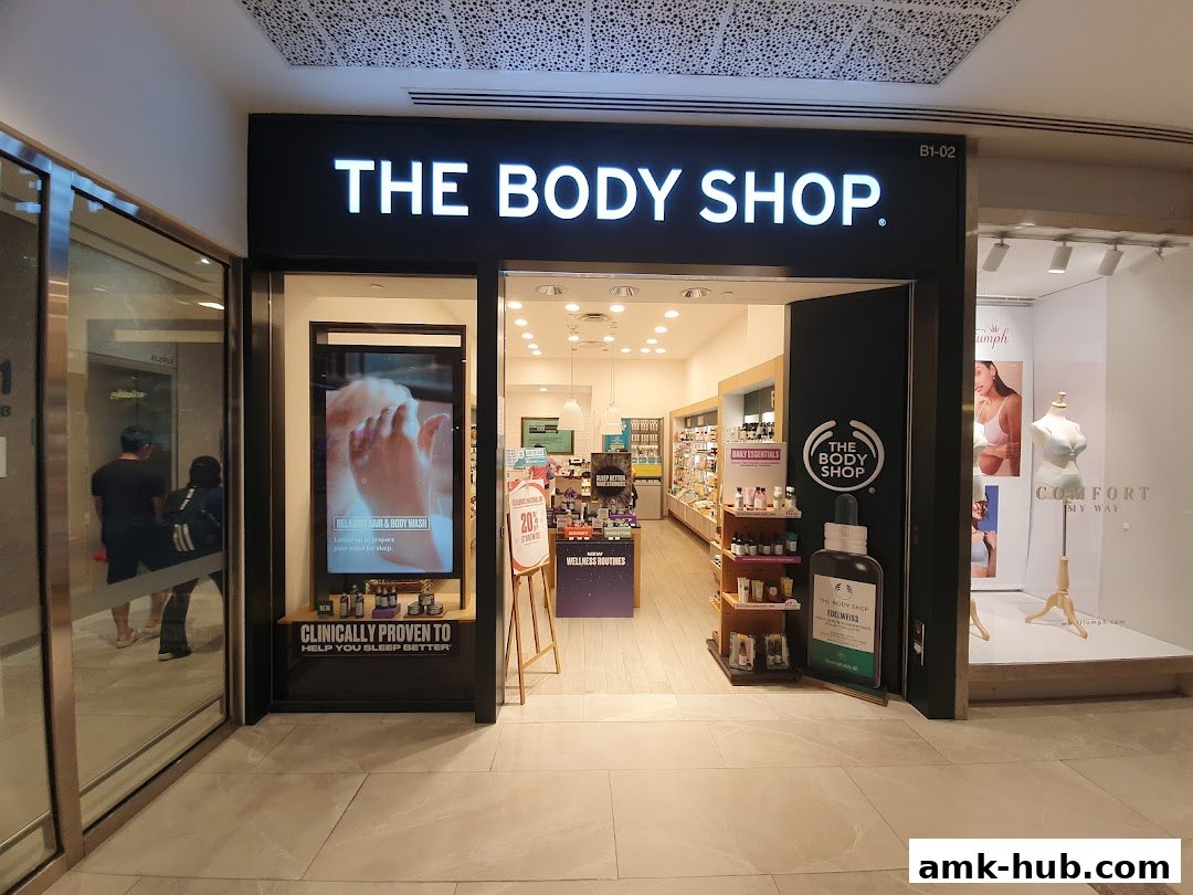 The Body Shop storefront with illuminated signage and an open entrance displaying products.