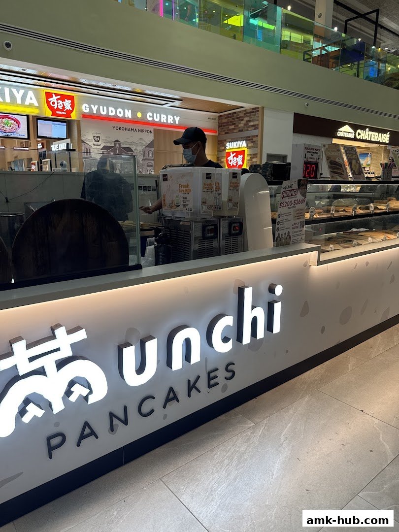 The illuminated sign for Munchi Pancakes is prominently displayed at the counter.