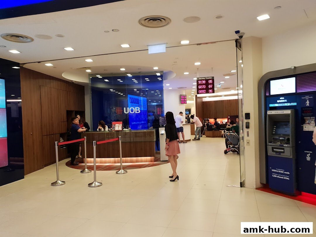 Interior view of a UOB bank branch with service counters, ATMs, and waiting customers.