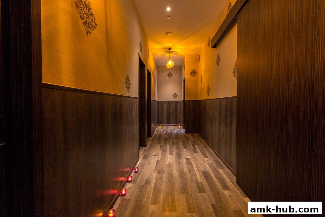 A dimly lit spa hallway with wooden floors, decorative walls, and candles.