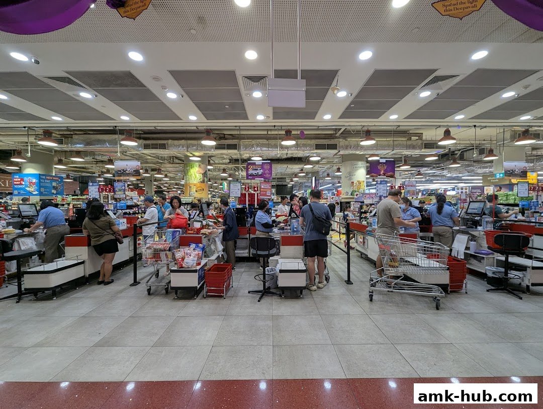 Customers are queuing at the checkout counters of a busy supermarket.