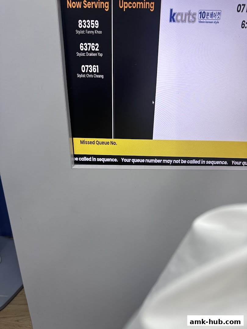 A screen displaying queue numbers and stylist names for a hair salon.