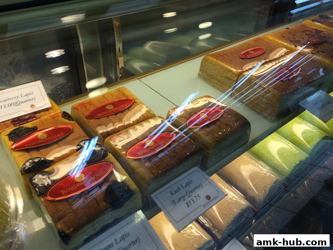 A display case filled with various layered cakes from Bengawan Solo.