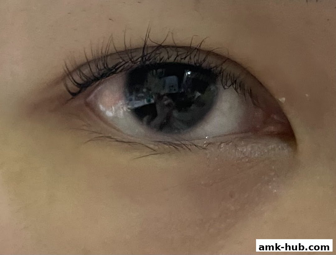 A close-up shot of a person's eye, reflecting lights and possibly a shop interior.