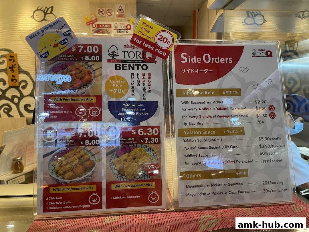 A menu board displaying Japanese bento boxes, yakitori, and side orders with prices.
