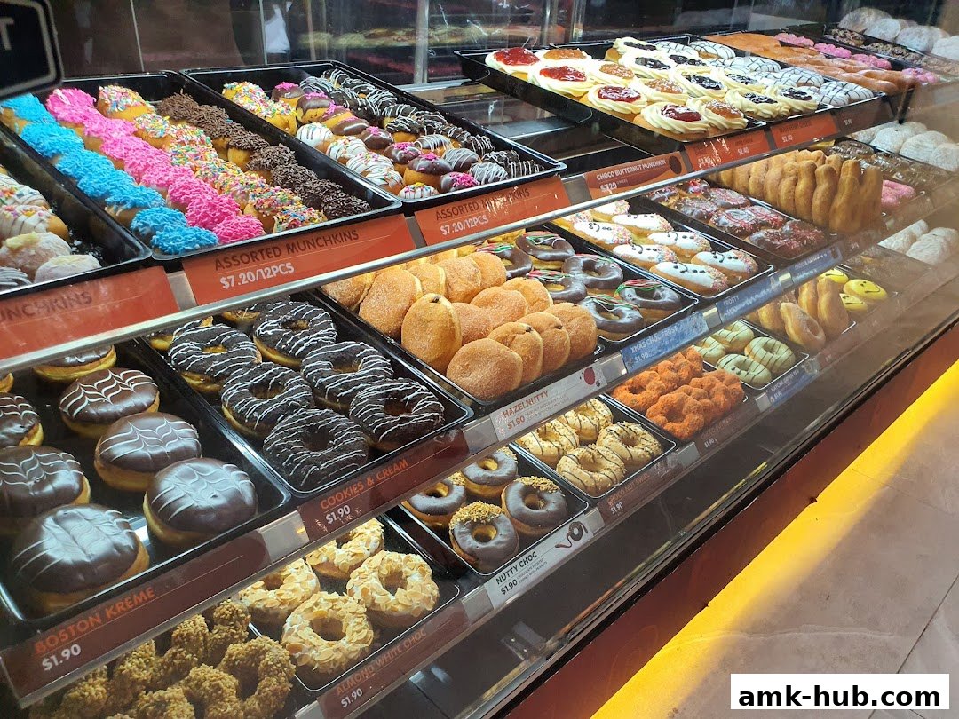 A display case filled with a variety of colorful and delicious donuts and munchkins.
