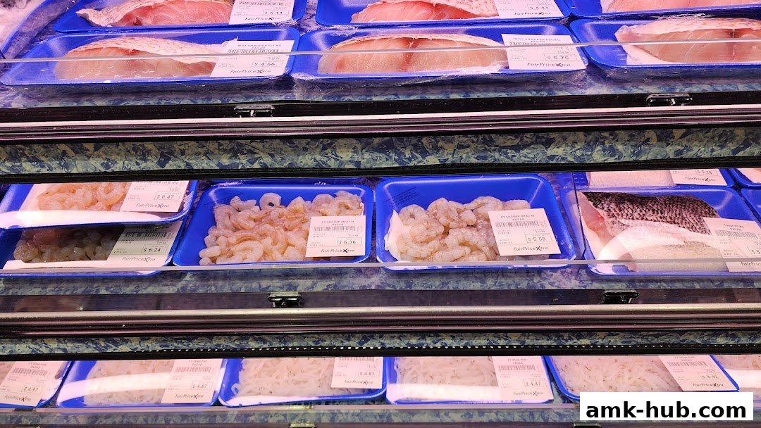 A display of fresh seafood, including fish and shrimp, packaged in blue trays.