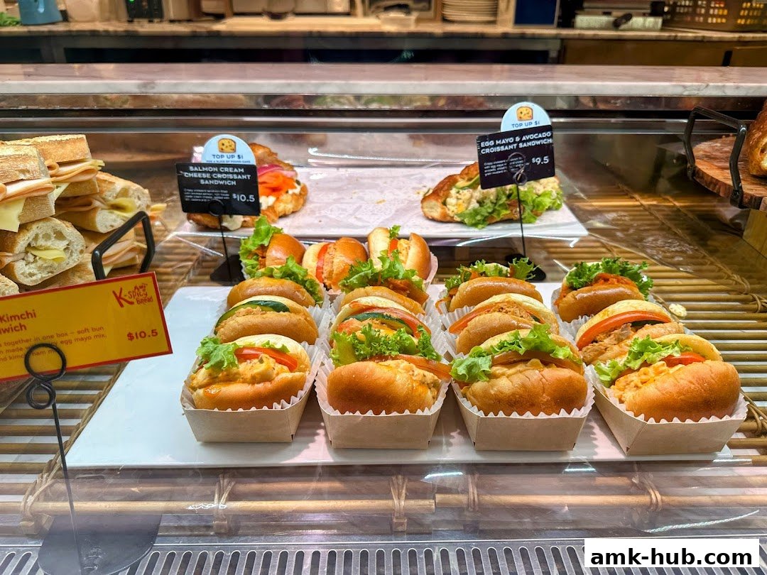 A display case filled with various sandwiches and croissants from Paris Baguette.
