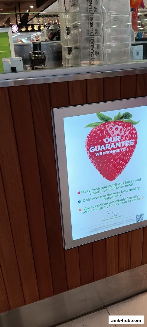 A digital display at Boost Juice featuring a large strawberry and their guarantee.