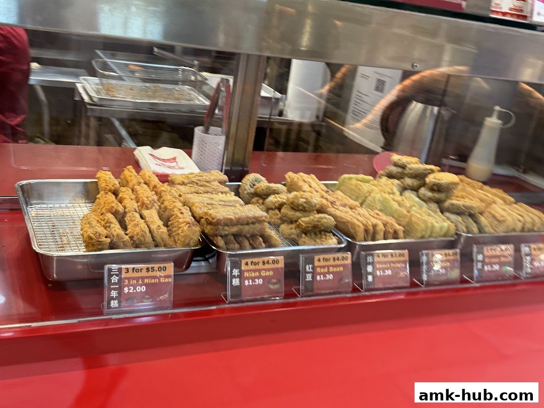 A display of various fried snacks, including Nian Gao and Red Bean items, at Yummi Bites.