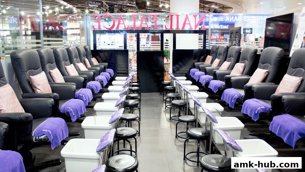 Rows of comfortable pedicure chairs with foot baths and purple towels at Nail Palace.