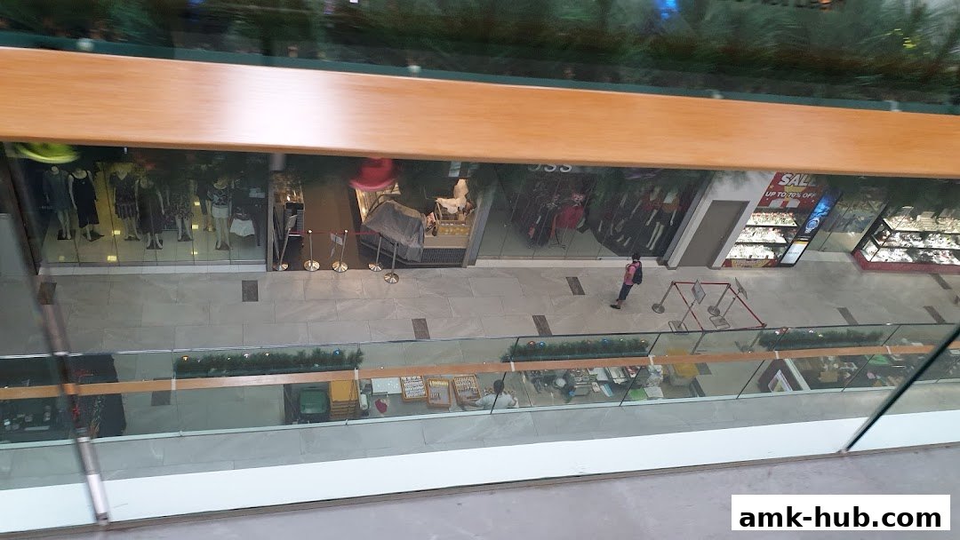 An overhead view of a shopping mall corridor with several shop fronts visible.