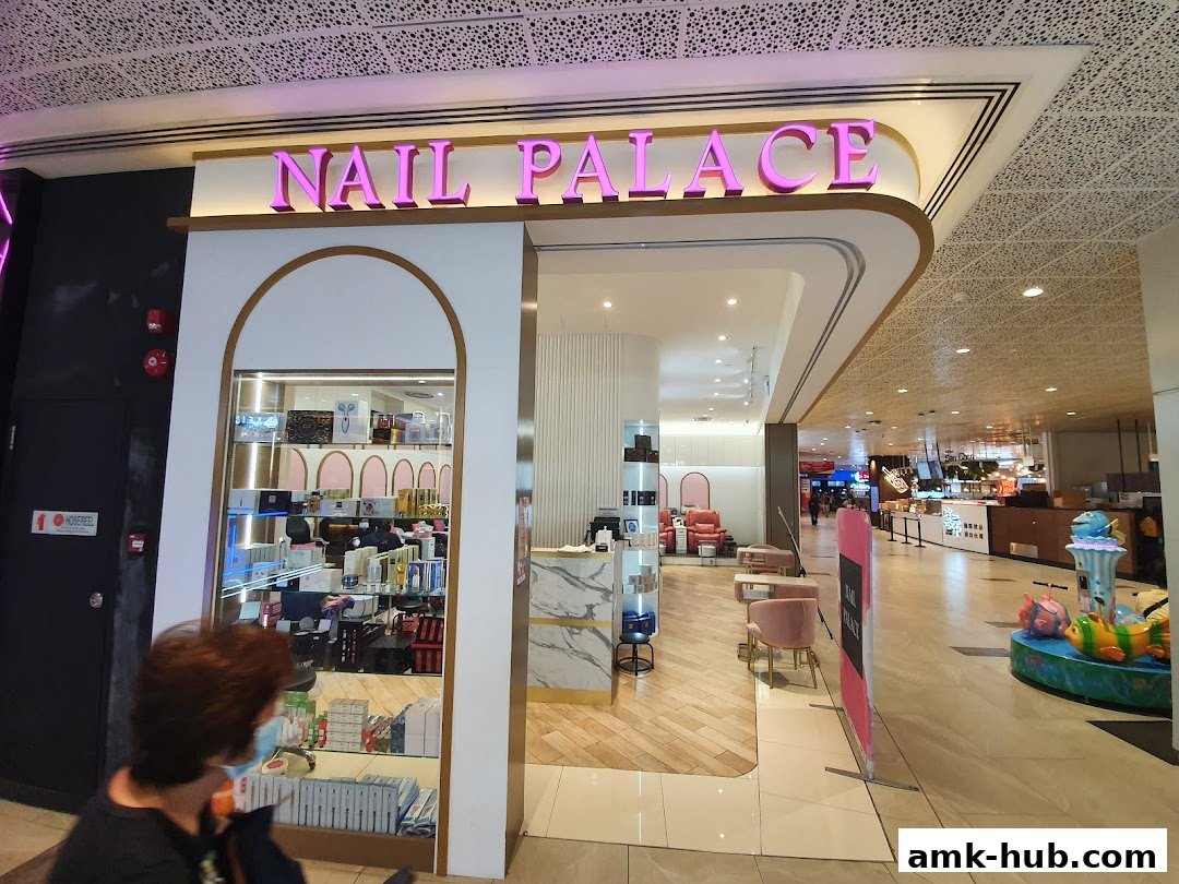 The entrance to Nail Palace, a modern nail salon with pink accents and display shelves.