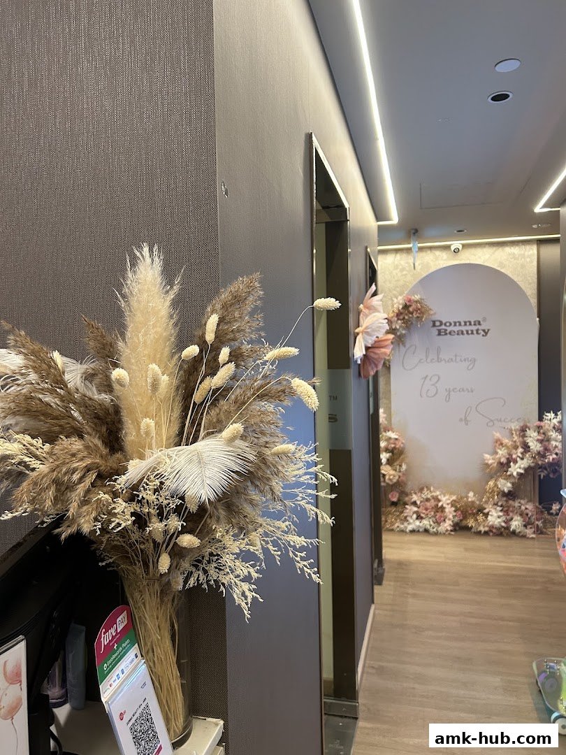 A stylish interior with a floral arrangement and a 'Donna Beauty' celebration backdrop.