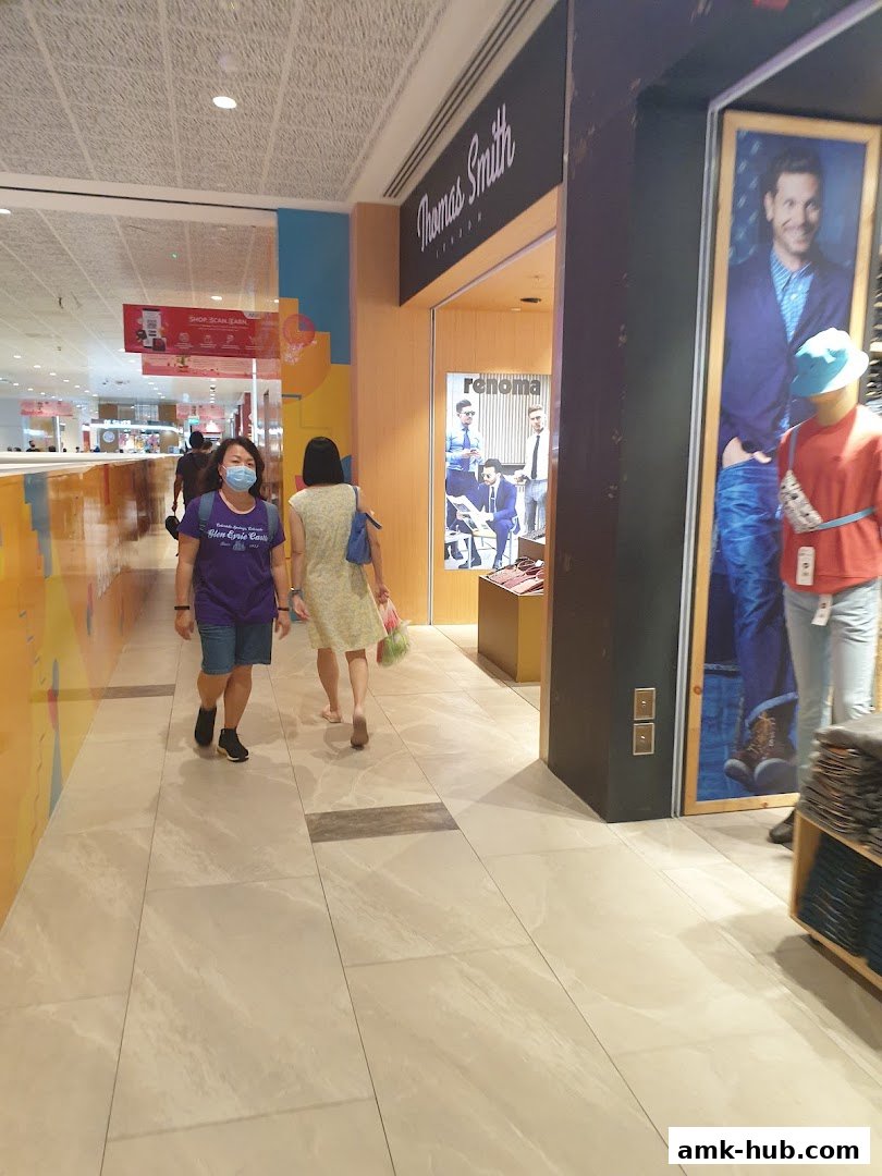 People walking past a Thomas Smith London shop with mannequins and advertisements.