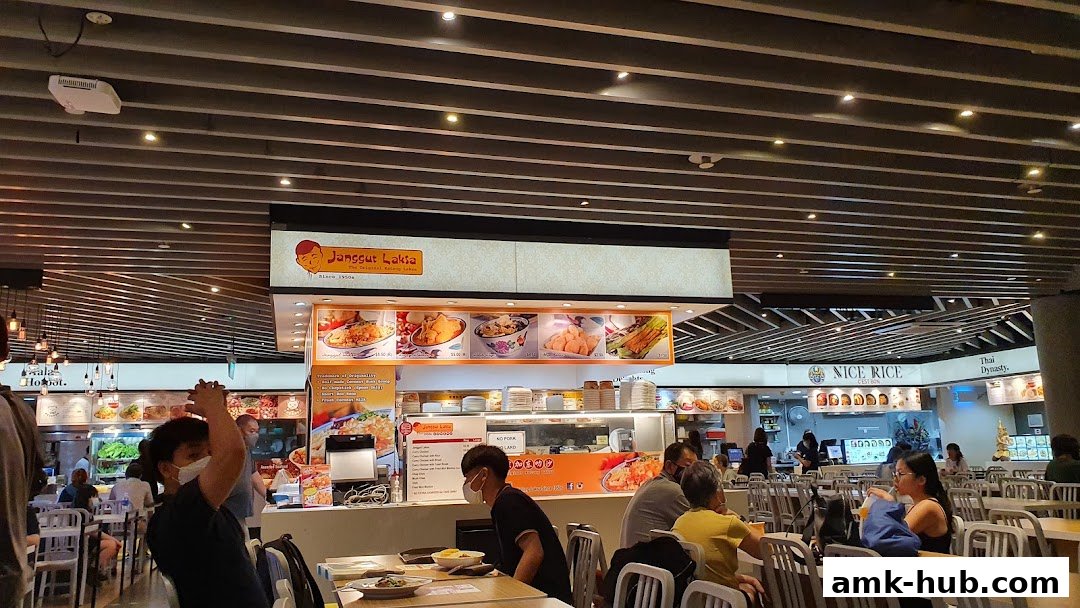 Interior view of a food court with multiple stalls, including Janggut Laksa.