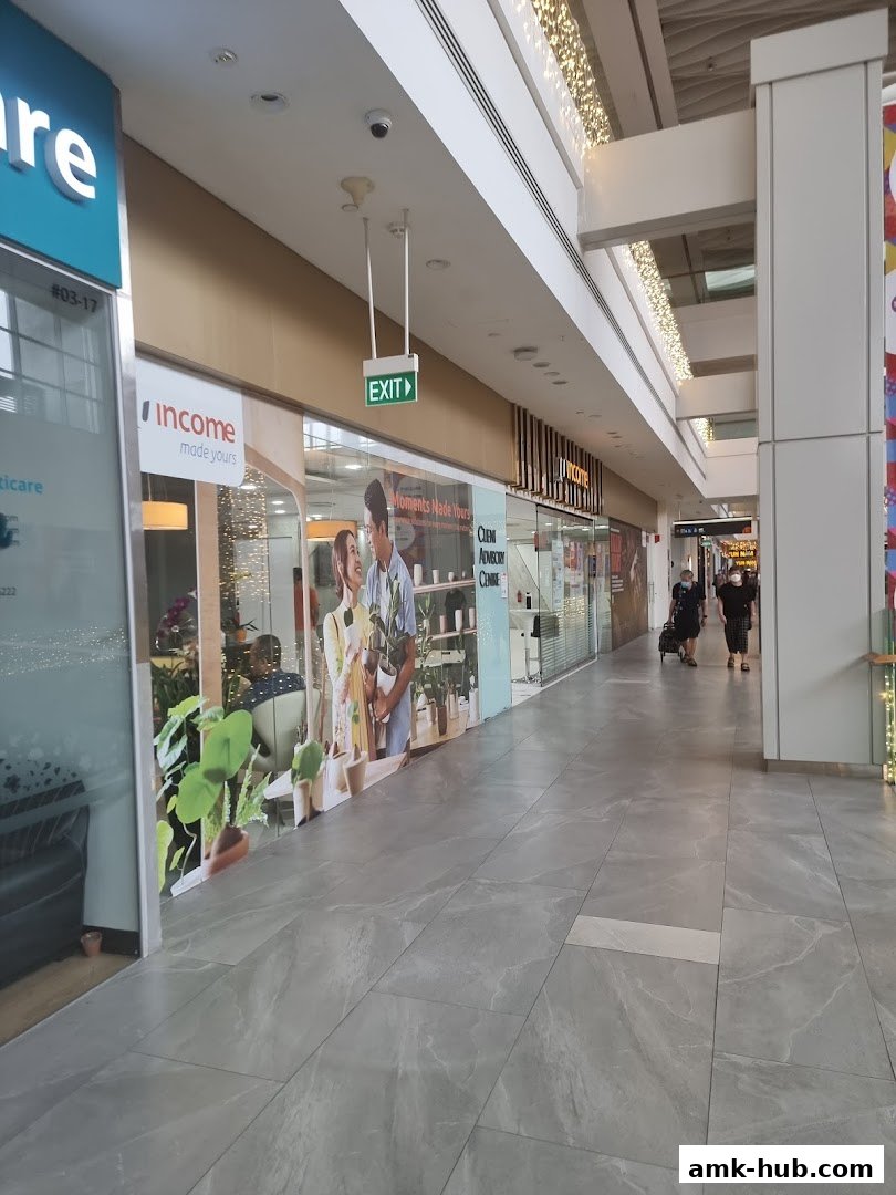 The exterior of the Income Insurance Ang Mo Kio Branch shop with signage and window displays.