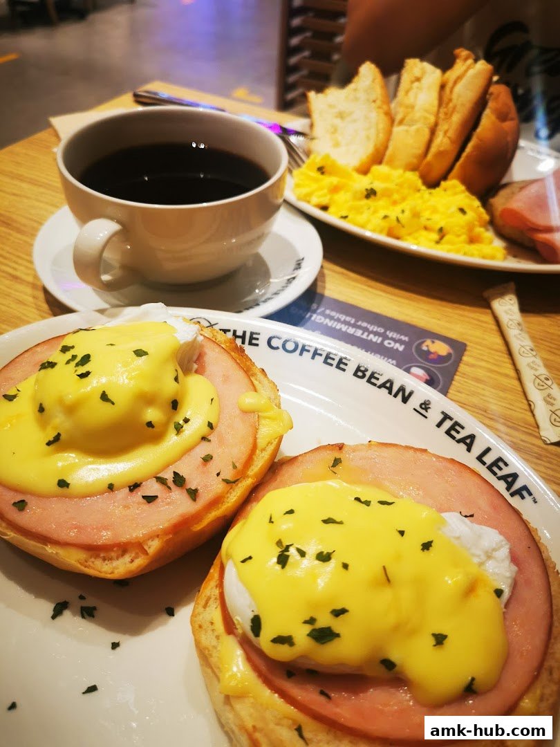 A close-up of Eggs Benedict and a breakfast platter with scrambled eggs, toast, and ham at The Coffee Bean & Tea Leaf.